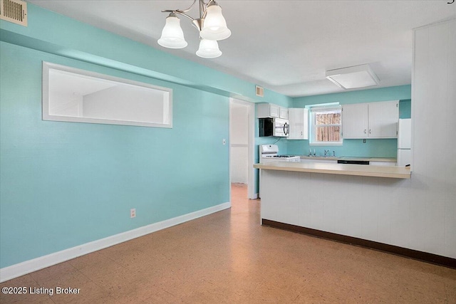 kitchen with pendant lighting, white cabinets, white fridge, range, and kitchen peninsula