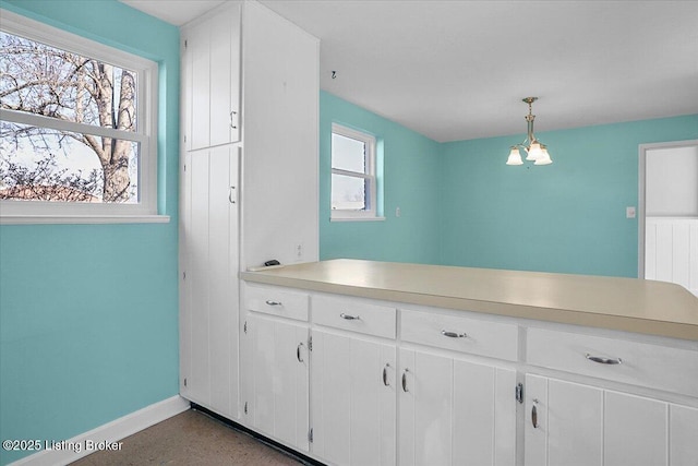 kitchen with white cabinetry and decorative light fixtures