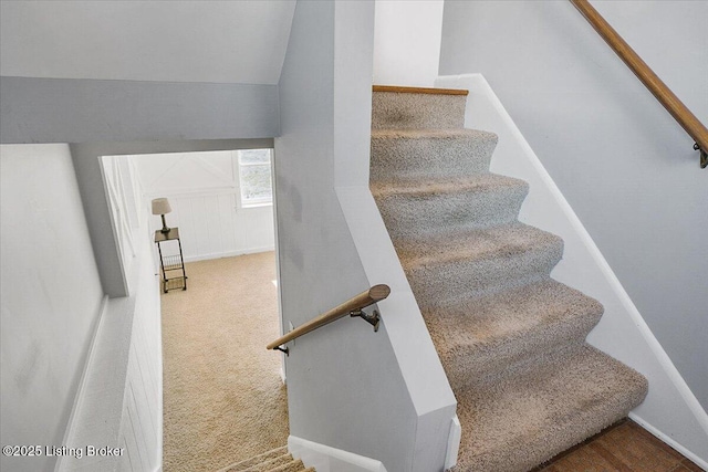 stairway with vaulted ceiling and carpet flooring