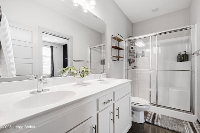 bathroom featuring vanity, an enclosed shower, and toilet