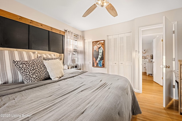 bedroom with ceiling fan, light hardwood / wood-style floors, and two closets