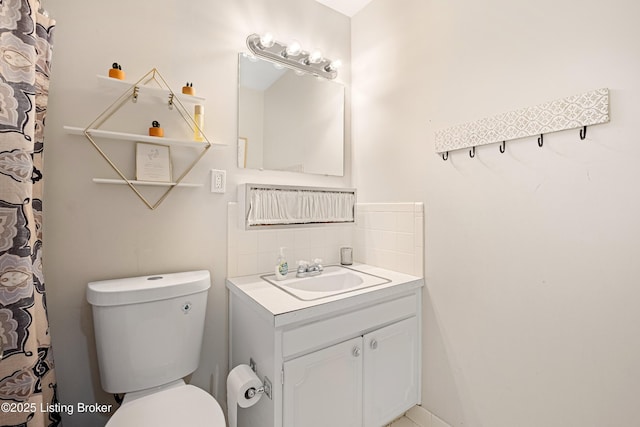 bathroom with vanity, toilet, and backsplash