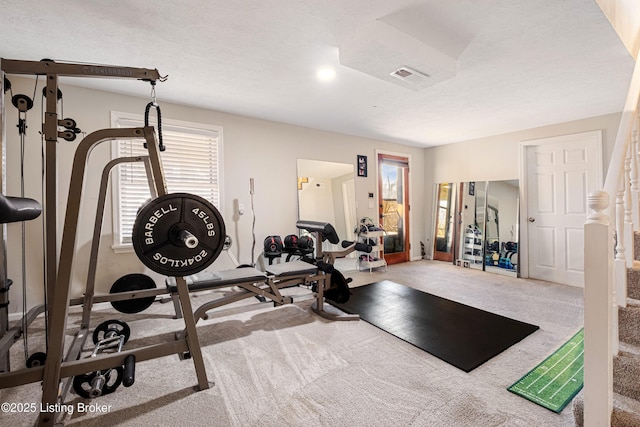 workout room with carpet flooring and a textured ceiling