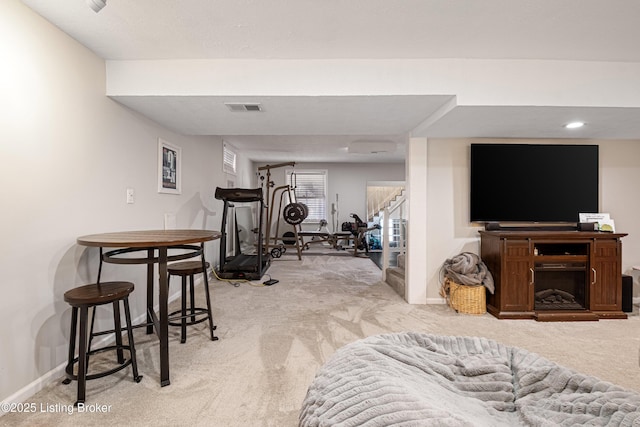 workout room featuring light carpet