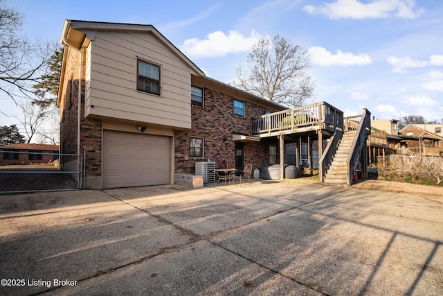 rear view of house with a garage and a deck