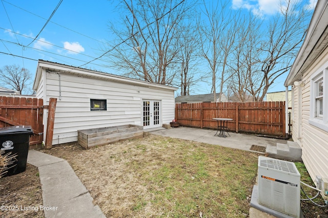 rear view of house with french doors, a patio, and a lawn