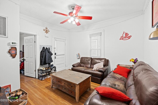 living room with hardwood / wood-style flooring, crown molding, and ceiling fan