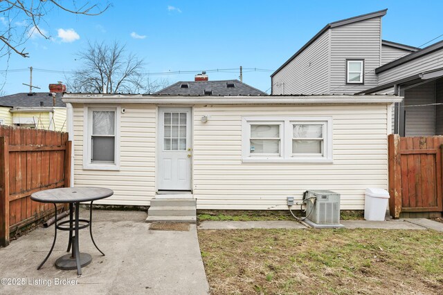 back of property featuring cooling unit, a yard, and a patio area