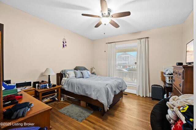 bedroom featuring ceiling fan, dark hardwood / wood-style floors, and radiator