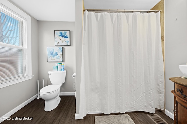 bathroom featuring wood-type flooring and toilet