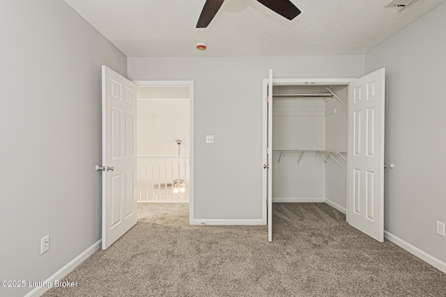 unfurnished bedroom with light carpet, ceiling fan, a closet, and a textured ceiling