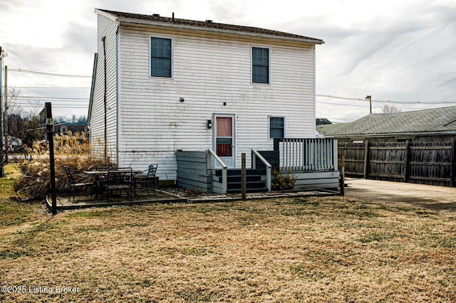 rear view of property featuring a lawn, a patio, and a deck