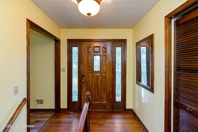 foyer entrance featuring a textured ceiling and dark hardwood / wood-style flooring