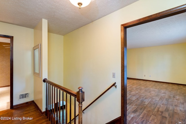 corridor featuring hardwood / wood-style flooring and a textured ceiling