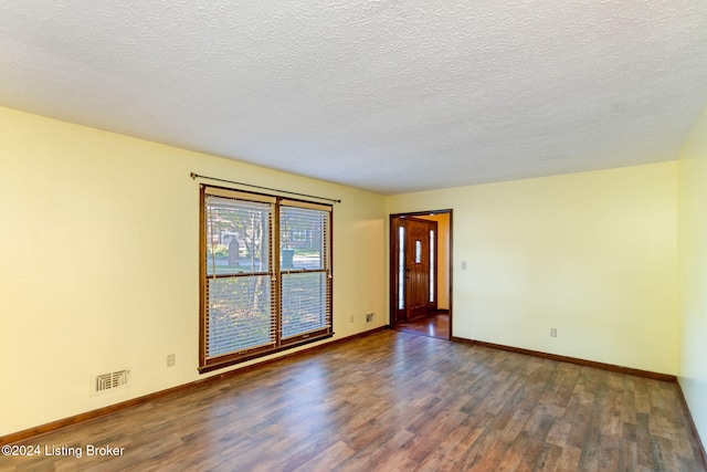 unfurnished room featuring dark hardwood / wood-style flooring and a textured ceiling