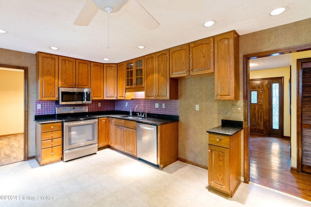 kitchen with tasteful backsplash, sink, stainless steel appliances, and ceiling fan