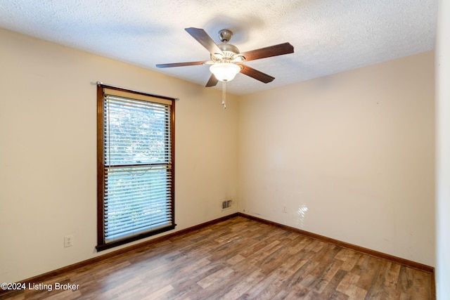 spare room featuring hardwood / wood-style flooring, ceiling fan, and a textured ceiling