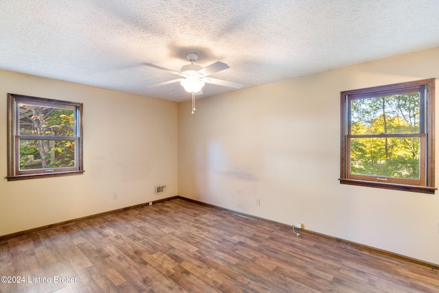 spare room with ceiling fan, hardwood / wood-style flooring, and a textured ceiling