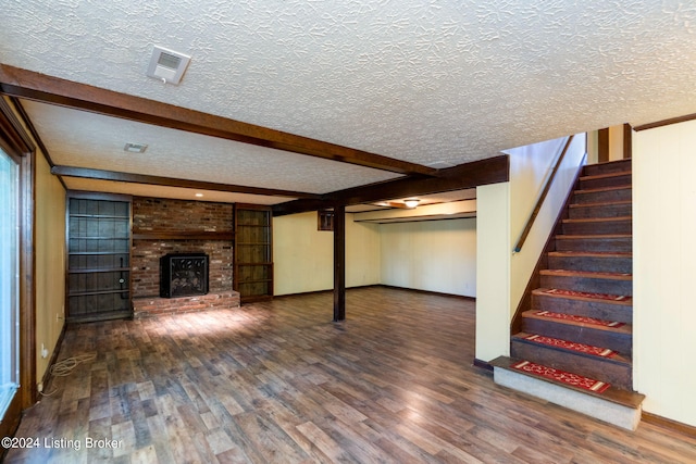 basement featuring a fireplace, dark hardwood / wood-style floors, and a textured ceiling