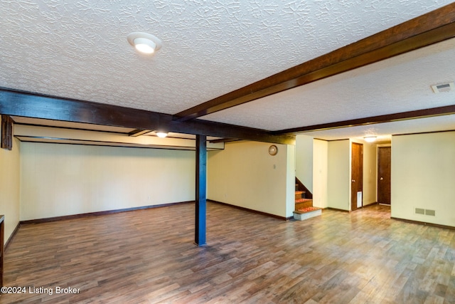 basement with hardwood / wood-style flooring and a textured ceiling