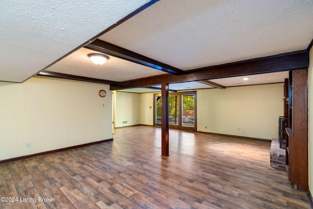 basement featuring wood-type flooring and a textured ceiling