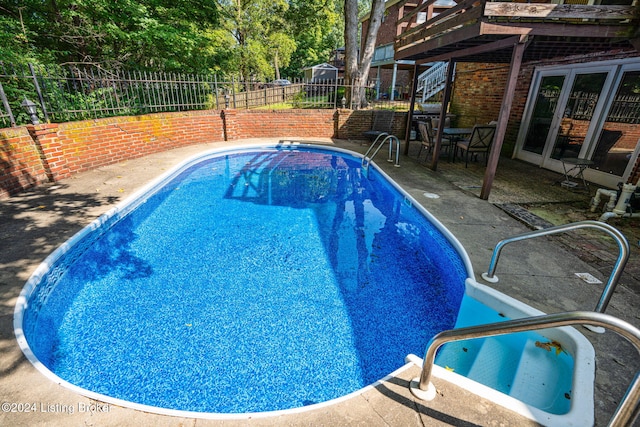 view of swimming pool featuring french doors and a patio