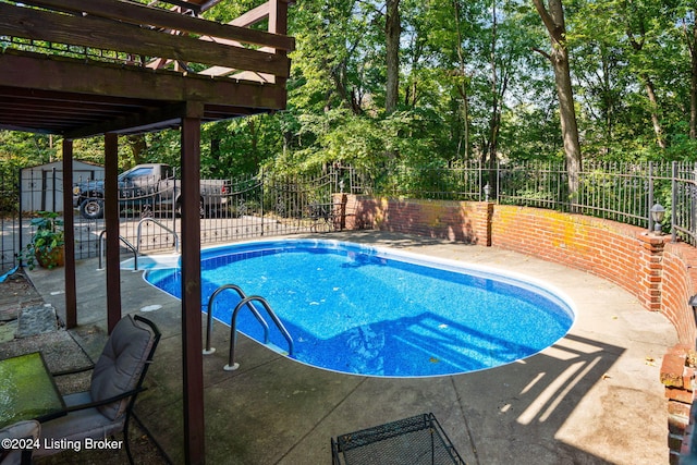 view of pool with a storage shed and a patio area