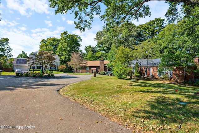 view of front facade featuring a front lawn and solar panels