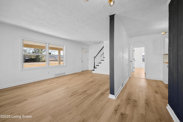 interior space with a textured ceiling and light hardwood / wood-style flooring