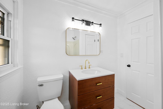 bathroom with vanity, ornamental molding, and toilet