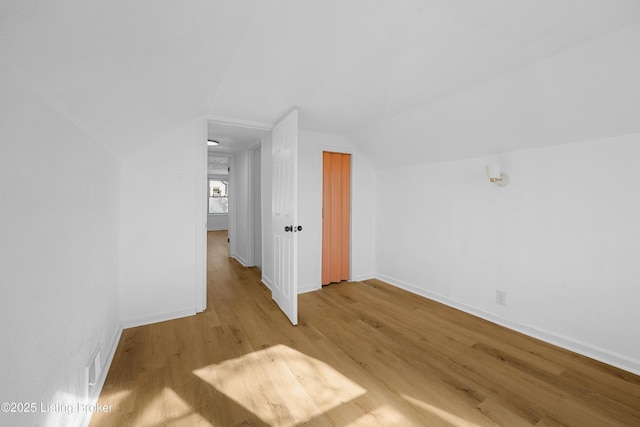 bonus room featuring lofted ceiling and light wood-type flooring