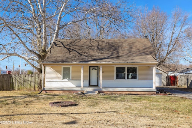 view of front of home featuring a garage, an outdoor structure, a porch, and a front yard