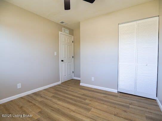 unfurnished bedroom featuring ceiling fan, wood-type flooring, and a closet