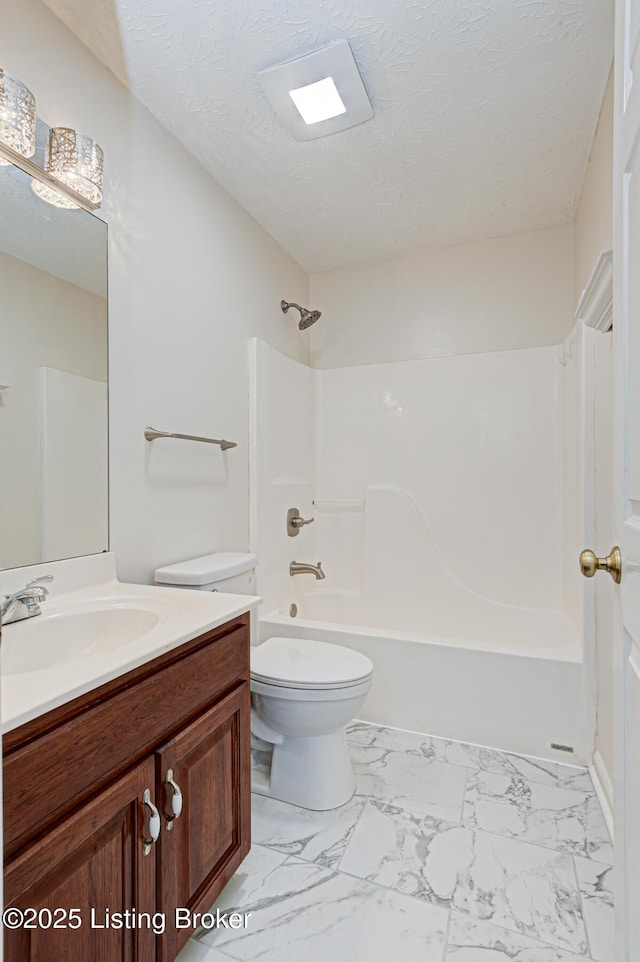 full bathroom featuring toilet, vanity, a textured ceiling, and tub / shower combination