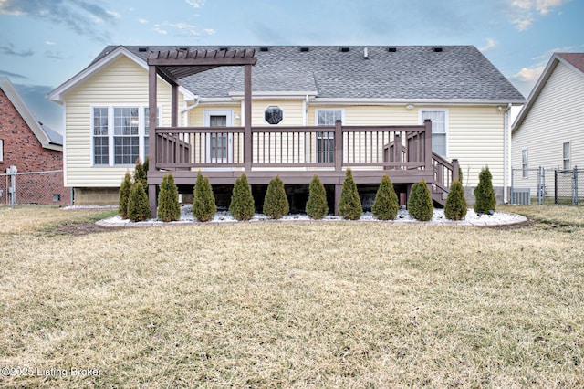 rear view of property with a lawn, a deck, and a pergola