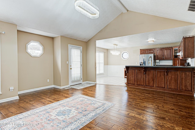 interior space featuring a notable chandelier, vaulted ceiling with beams, and dark hardwood / wood-style floors