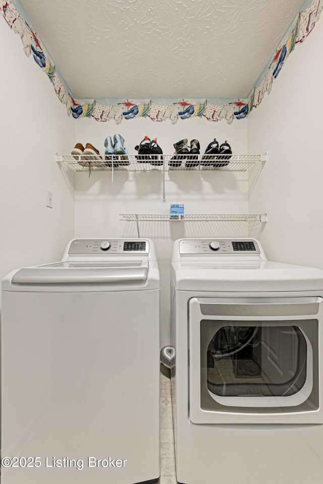 laundry area with washer and dryer and a textured ceiling