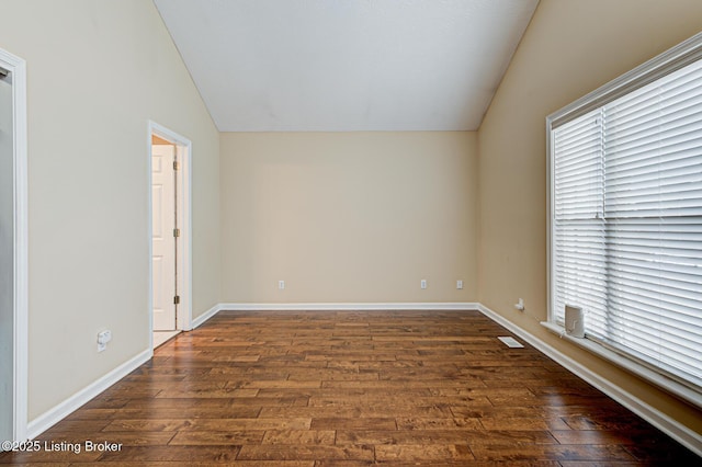 unfurnished room with dark wood-type flooring and lofted ceiling