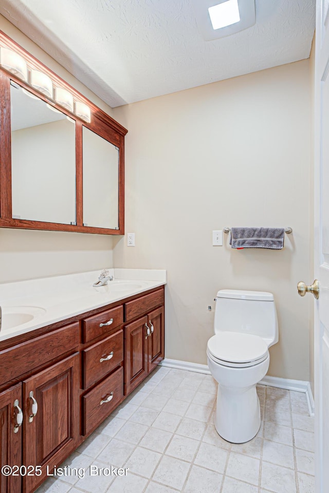 bathroom featuring a textured ceiling, toilet, and vanity