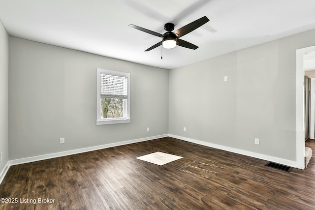 empty room featuring dark wood-type flooring and ceiling fan