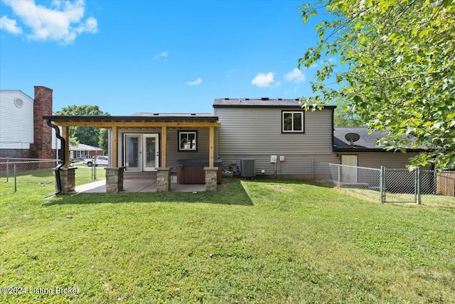 back of property featuring cooling unit, french doors, a patio, and a lawn