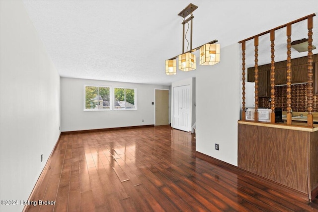 unfurnished dining area featuring dark hardwood / wood-style flooring and a textured ceiling