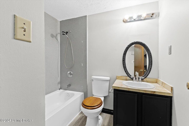 full bathroom featuring  shower combination, vanity, wood-type flooring, a textured ceiling, and toilet