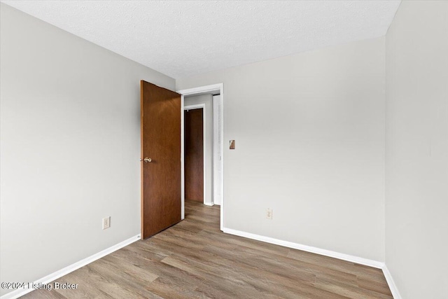 empty room featuring light hardwood / wood-style floors and a textured ceiling