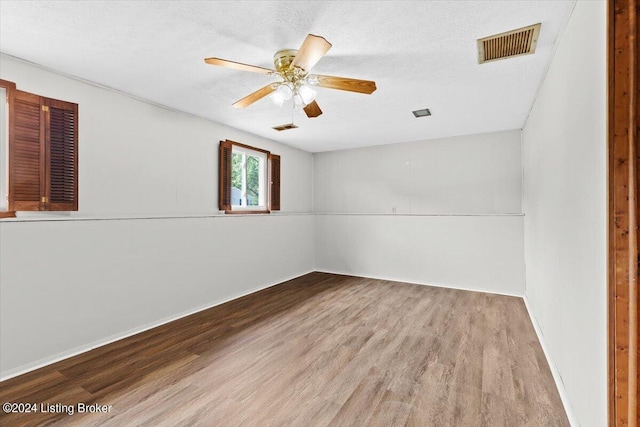 spare room featuring a textured ceiling, ceiling fan, and light hardwood / wood-style flooring