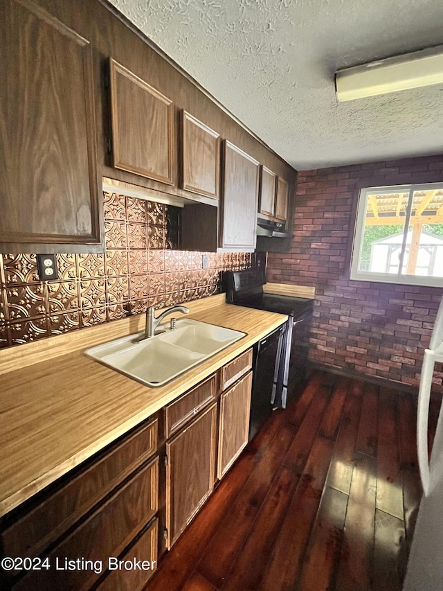 kitchen featuring dark hardwood / wood-style floors, sink, black appliances, dark brown cabinets, and a textured ceiling