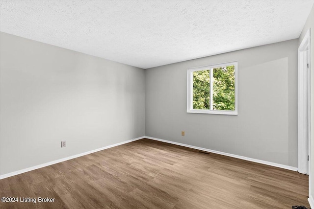 empty room featuring light hardwood / wood-style flooring and a textured ceiling