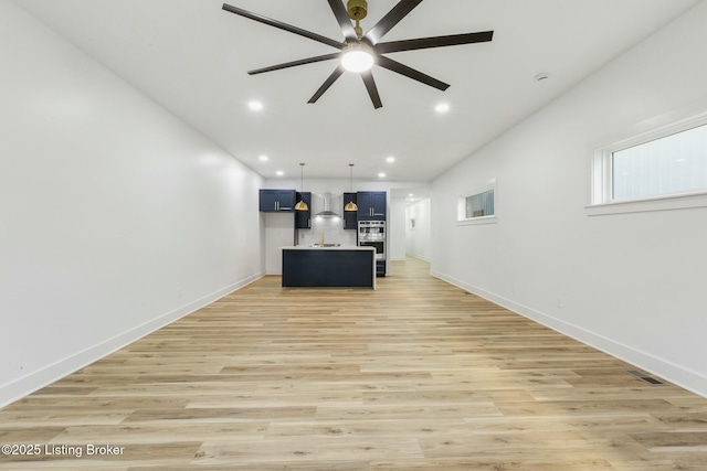 unfurnished living room with ceiling fan and light wood-type flooring