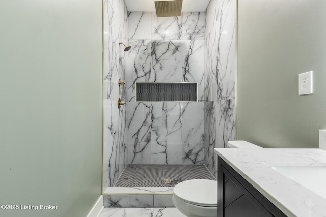 bathroom featuring vanity, toilet, and tiled shower