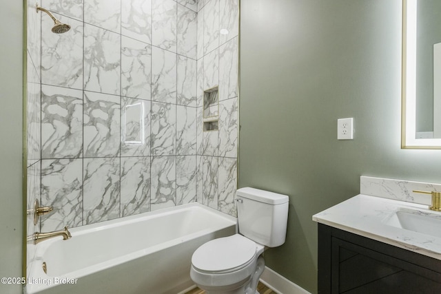 full bathroom featuring tiled shower / bath, vanity, and toilet